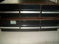 Multiple wooden cassette storage cases with compartments for tapes in black plastic holders.