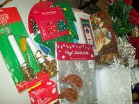 Various Christmas decoration items including melamine serving plates, salt and pepper shakers, electric candles, reindeer figurines, and vinyl tablecloth.