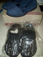 Pair of quilted navy blue women's slippers on top of Foam Treads box, brand new condition.