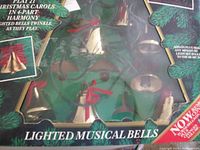 Close-up image of the box showing text indicating the set can play 21 Christmas carols in 4-part harmony, with lighted bells twinkling as they play.