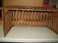 Wooden nativity creche showing open side and interior with slatted roof and walls.