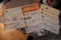 Full view of all 14 old Canadian bank cancelled cheques, showing multiple banks and stamped marks