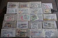 Overview of twenty small envelopes containing assorted world stamps in various conditions and themes.