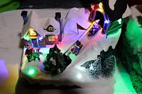 Photo showing the toboggan hill with sledding figurines and illuminated windows and hill with multicolored LED lights.