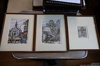 Three framed lithographs displayed together on a table, showing the full lot and size scale