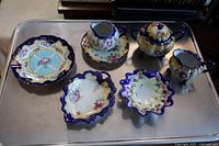 Full set of 8 Nippon pieces arranged on a metal tray showing size and decoration
