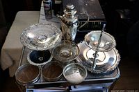 Overview of all 8 silverplate serving pieces, including two-tier stand, large tray, cocktail shaker, mesh bowl, and serving dishes