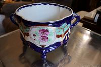 Photo of the vintage Jardinair ceramic plant pot showing front floral design and handles