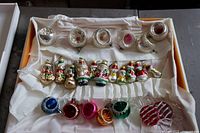 Full overview of all 22 Christmas ornaments laid in box, showing diversity of glass balls, figures, and candy shapes.