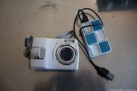 Full camera and card reader with attached USB cable on surface.