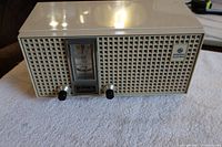 Front view of vintage General Electric Super Six radio with tuning dial, two knobs, and GE logo.
