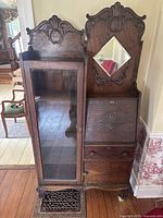 Full front view showing carved top crest, glass door on left, drop-front desk on right, drawers and feet