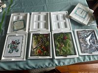 Four bird-themed collector plates displayed in their individual protective Styrofoam packaging on a table.