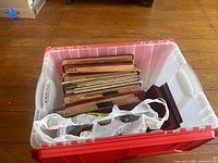 Top view showing multiple vintage record sleeves stacked in a plastic container indicating quantity and condition.
