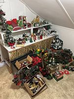 Wide shot showing shelves and floor covered with various Christmas decorations including wreaths, figurines, and boxed ornaments.