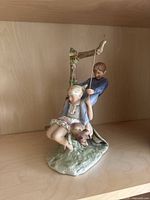 Front angle showing boy holding swing rope, girl on swing, and dog.