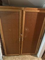 Closed old wooden armoire with two paneled doors and metal handles