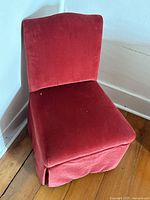Red upholstered retro parlour chair showing front angle, fabric texture, and wear.