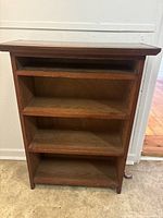Front view of solid wood shelf with visible shelves.