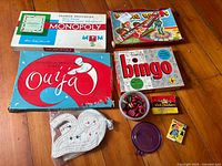 Full view of the lot showing all game boxes and pieces on wooden floor