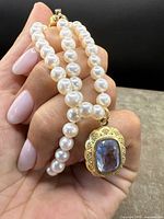 Close-up of pearl beads and blue stone pendant