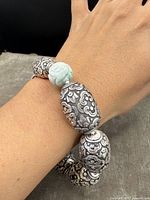 Bracelet worn on wrist showing size and bead details with silver metal and jade beads.