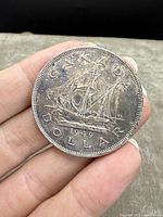 Front side of the 1949 Canadian Silver Dollar showing the ship design and year.