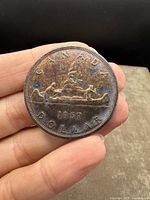 Obverse side showing two men paddling a canoe with the inscriptions 'CANADA DOLLAR 1957'