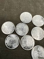 Top view of obverse sides of eight American silver bullion coins showing the American Eagle design.