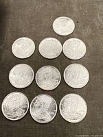 Ten American Silver Eagle 1/10 oz silver bullion coins arranged on a surface with clear visibility of the Walking Liberty design and inscriptions.