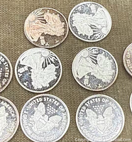 Close-up view of the fronts and backs of several silver bullion coins showing Liberty and eagle designs.