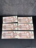 Front side of six uncirculated early Canadian $2 bank notes showing portrait of Queen Elizabeth II