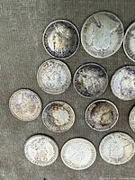 Top view of 13 early Canadian silver coins including dimes, quarters, and half dollar, showing obverse and reverse sides with visible tarnish and surface wear.
