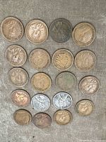 Top view showing 21 assorted coins including Canadian and American coins with various dates and portraits.