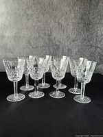 Front view of all eight wine glasses showing uniform cut patterns and clear crystal.