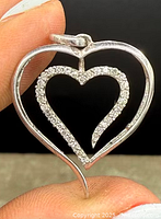 Close-up front view showing the open heart pendant with sterling silver and diamond accents.