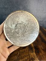 Close-up of the silver-plated dish showing the detailed folk tale etched scene of two figures in a garden setting, with inscription 'Printemps'.