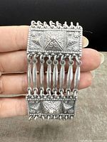Front view of antique silver bracelet showing detailed embossing and links.