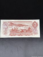 Front side of the uncirculated early Canadian $2 bank note showing workers and rural imagery with denomination markers.