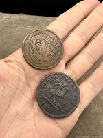 Two early Canadian tokens displayed on a hand, showing obverse and reverse with inscriptions and designs.