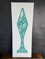 Full view of one paddle print with teal indigenous graphics on white background, showing signature and edition number at bottom.