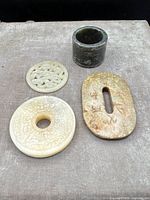 Group shot showing all four jade carvings on grey background