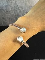 Photo of bracelet worn on wrist showing crossover design and moonstones at each end.
