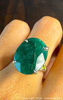 Close-up top view of the ring displaying the oval emerald center stone in four-prong setting