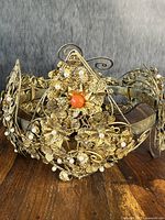 Front view of antique Chinese gilt-metal filigree crown showing coral centerpiece and natural pearl decoration