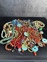 Pile of assorted gemstone bead necklaces in various colors and shapes
