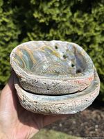 Close-up view of two stacked large abalone shells showing iridescent interior and rough outer surface.