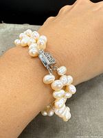 Photo showing the double-strand natural pink pearl bracelet worn on wrist, highlighting the pearl texture and the clasp.