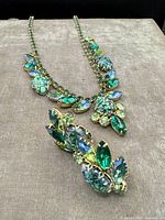 Full view of necklace with green, blue, and teal rhinestones set in gold-tone metal.