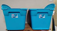 Two blue Sterlite storage totes side by side, both with lids open showing condition and size.